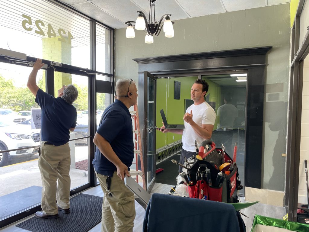 Michael Benso, BUZOPS co-Founder assisting in the installation of the new 24h access hardware at EnerGym North JAX and making sure all members walking in have immediate access to the gym and their attendance is accurately reflected in their members account in BUZOPS.