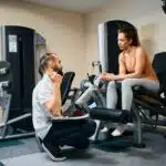 Gym trainer talking to member